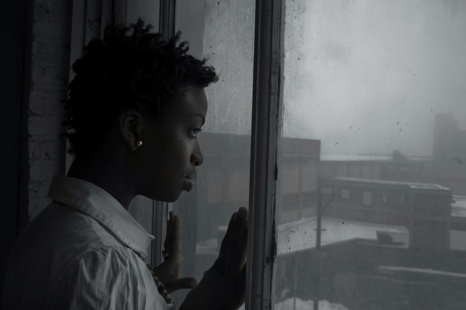 woman looking out window on dark day